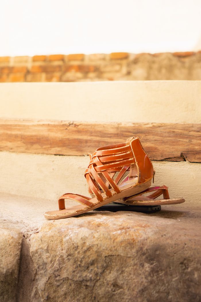 about-01 Elegant leather sandals placed on a stone surface, creating a rustic and modern feel.