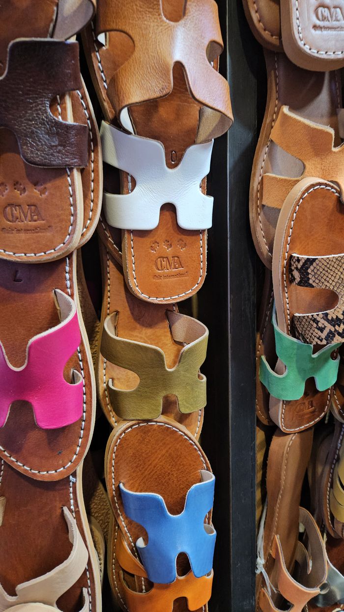 services-01 Close-up of various colorful leather sandals neatly displayed in a store.